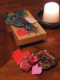 Talismán de enamorados elaborado con perejil, salvia, romero y tomillo, junto a una vela y un platito de especias secas.