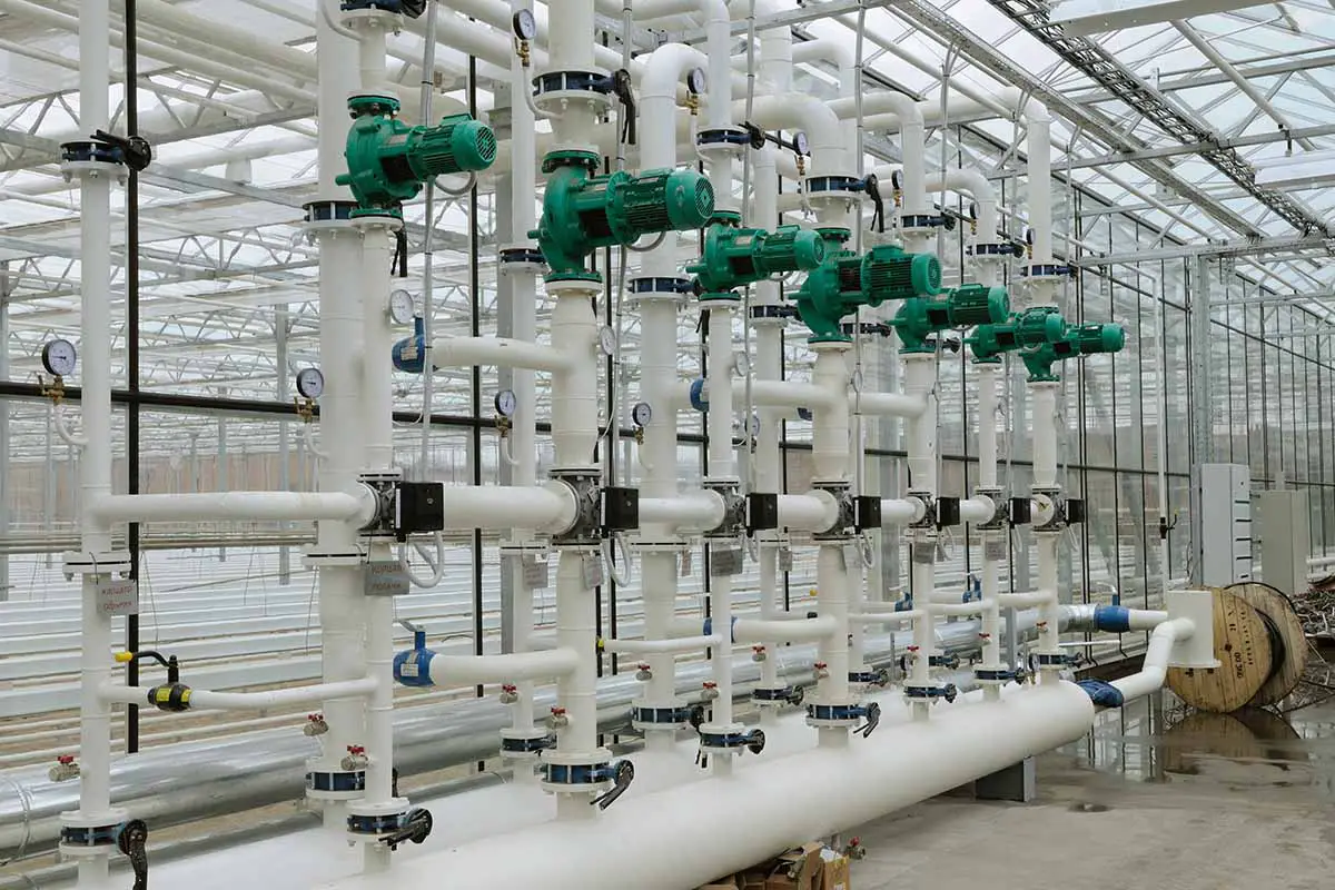 Una imagen horizontal de un gran sistema de tuberías para calentar un invernadero comercial.