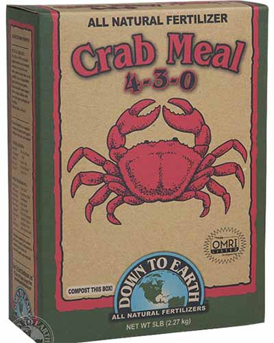 Una imagen cuadrada de primer plano de una caja de Down to Earth's Crab Meal representada sobre un fondo blanco.