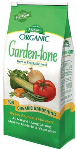Un primer plano del envase verde y blanco del fertilizante tonal Espoma Garden para jardines orgánicos.