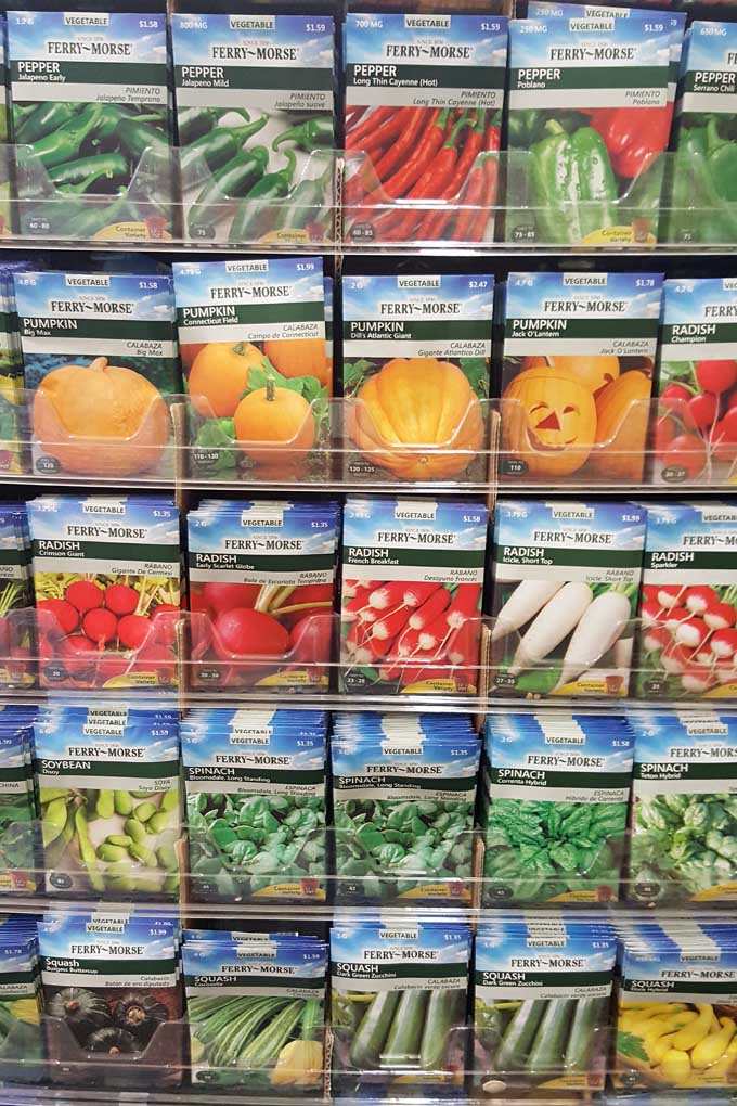 Una imagen vertical de primer plano de un estante de paquetes de semillas en un centro de jardinería.